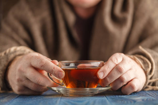 istock Hot tea in glass cup in male hands 850996198