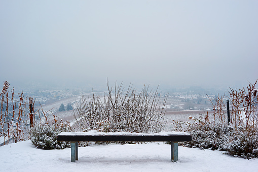 Photo of a romantic bench in snow covered landscape.