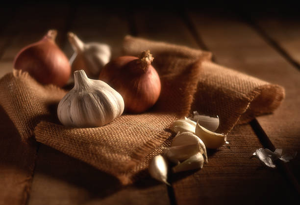 Onion and Garlic Onion, Garlic and Garlic Cloves with burlap on a wooden background garlic bulb photos stock pictures, royalty-free photos & images