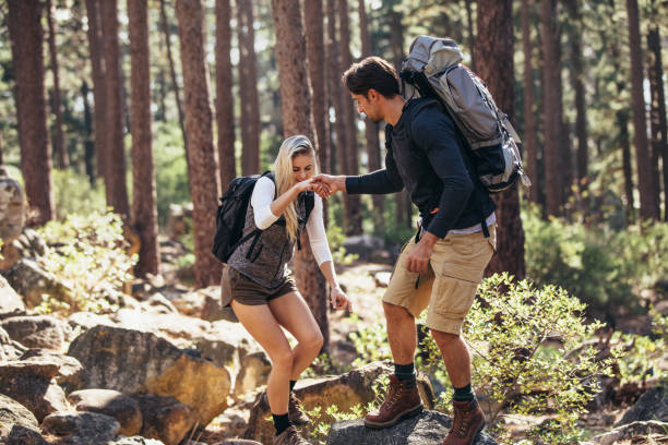istock Hiking couple walking on rocks in forest wearing backpacks 851012148