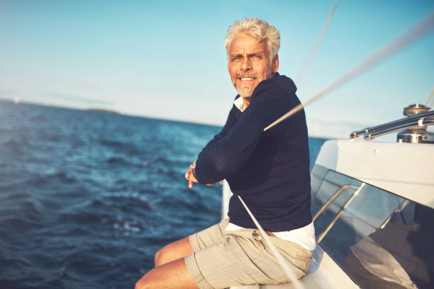 istock Mature man sitting on his sailboat looking at the ocean 851031376