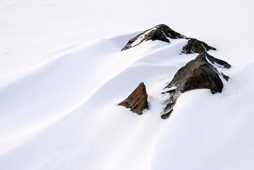 Rocks and wind sculpted patterns on snow