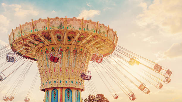 carousel ride spins fast in the air at sunset - vintage filter effects - a swinging carousel fair ride at dusk carousel ride spins fast in the air at sunset - vintage filter effects - a swinging carousel fair ride at dusk carousel photos stock pictures, royalty-free photos & images
