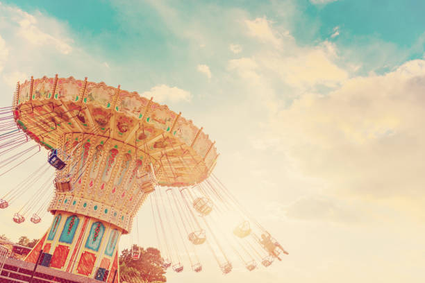 карусель ездить спины быстро в воздухе на закате - старинные эффекты фильтра - размахивая карусель справедливой езды в сумерках - carnival amusement park swing traditional festival стоковые фото и изображения