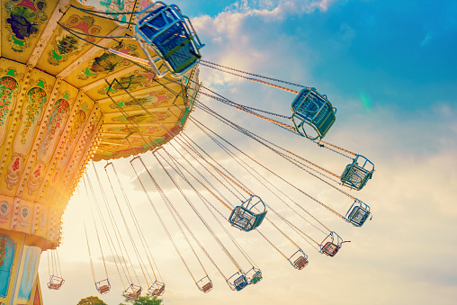 carousel ride spins fast in the air at sunset - vintage filter effects - a swinging carousel fair ride at dusk