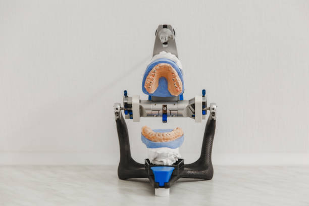 artikulator in ein dentallabor mit öffnen sie schimmel oder künstlichen prothese im dentallabor auf weißem hintergrund nahaufnahme - articulator stock-fotos und bilder