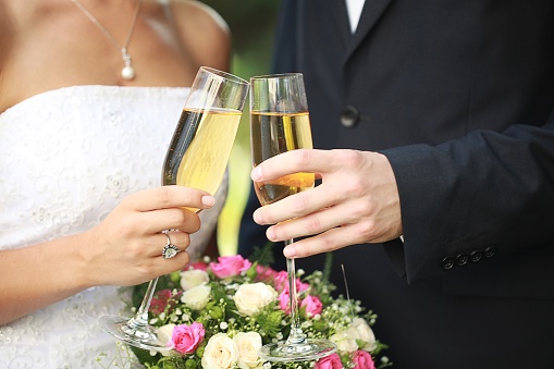Young Wedding Couple Bride and Groom holding champagne glasses