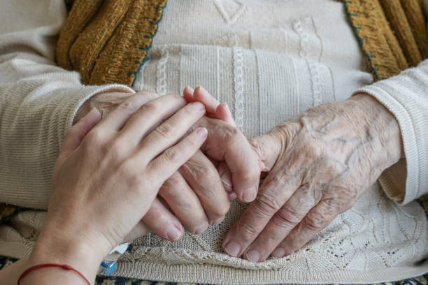 istock wrinkled hand holding a younger hand 851102724