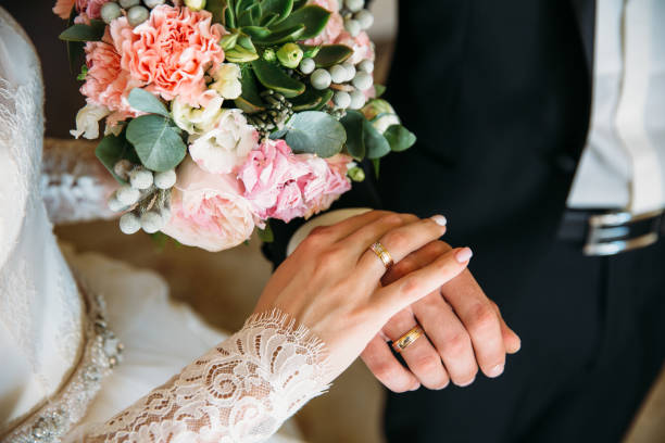 lo sposo e la sposa si tengono per mano agli anelli dello spettacolo di nozze. concetto di famiglia d'amore - wedding foto e immagini stock