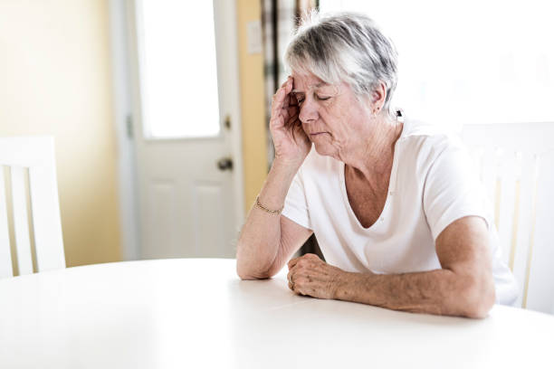 istock Mature woman at home touching her head with her hands while having a headache pain 851106444