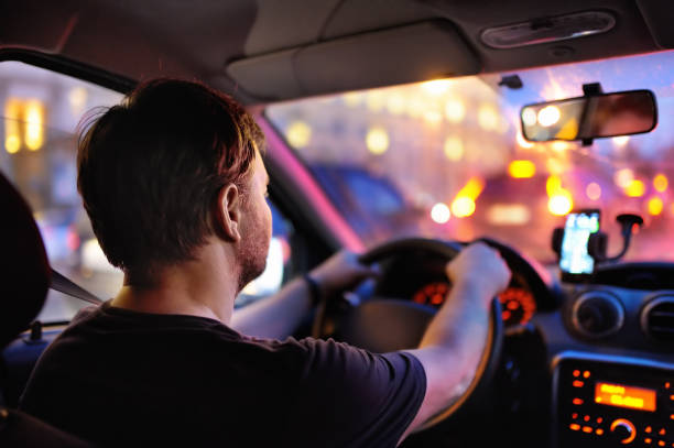 autista maschio in auto durante l'ingorgo serale - driving car traffic men foto e immagini stock