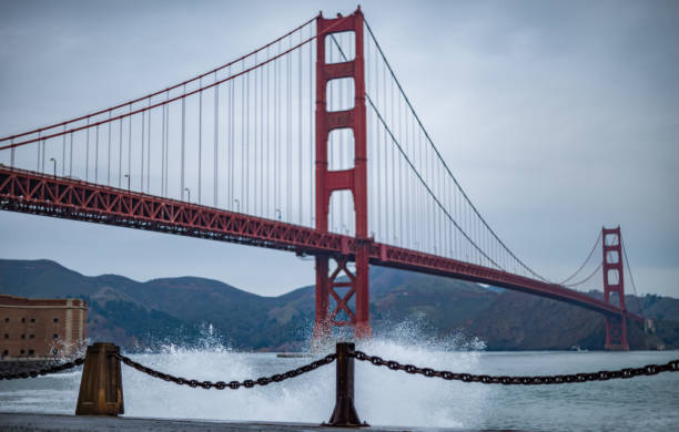 wellen brechen an der golden gate bridge - golden gate bridge bridge weather california stock-fotos und bilder