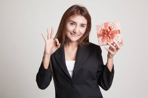 istock Young Asian woman show OK with a gift box. 851132964
