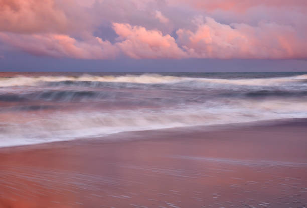 Atlantic Ocean at Sunset Dramatic clouds and heavy surf during a September sunset at Kure Beach, North Carolina cape fear stock pictures, royalty-free photos & images