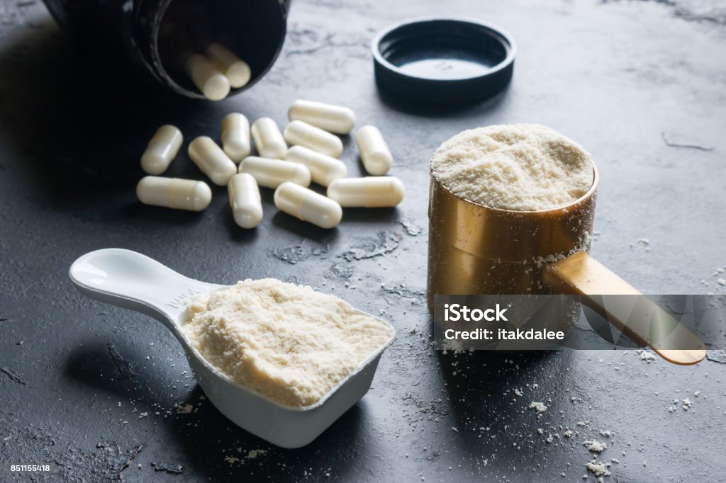 two measuring spoons of protein and creatine close-up on a black background Nutritional Supplement Stock Photo