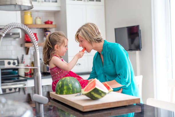 istock Mother and daughter cut watermelon in kitchen 851159474