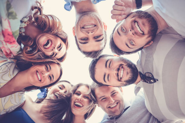 istock Group of Smiling Friends Creating Circle and Looking Down 851159582