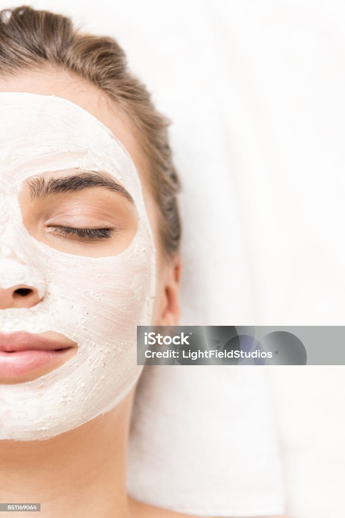 woman with facial mask spa therapy for woman with closed eyes receiving facial mask Facial Mask - Beauty Product Stock Photo