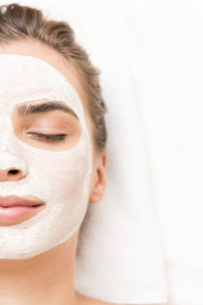 woman with facial mask spa therapy for woman with closed eyes receiving facial mask facial mask beauty product stock pictures, royalty-free photos & images