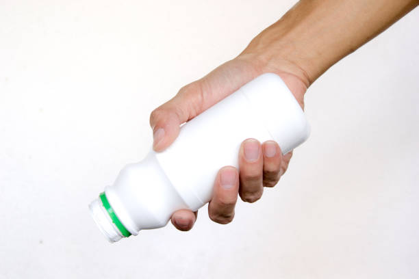 istock Hand holding open white bottle like a pouring on white background. Hand gesture 851169402