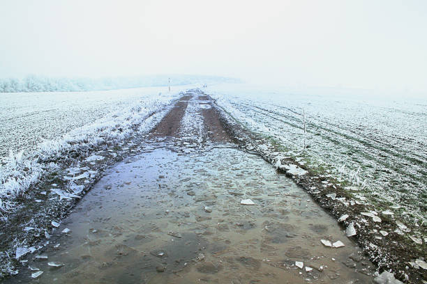 istock Winter frozen field road with cracked ice 851169638