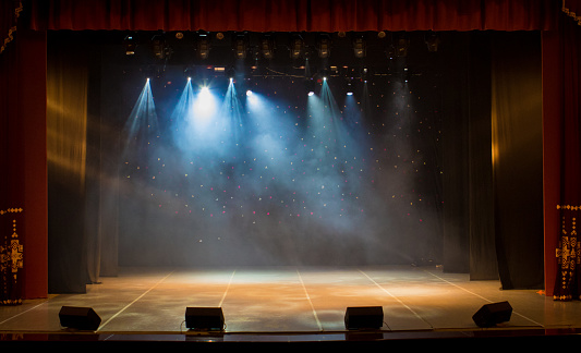El escenario del teatro iluminado por focos y humo del auditorio photo