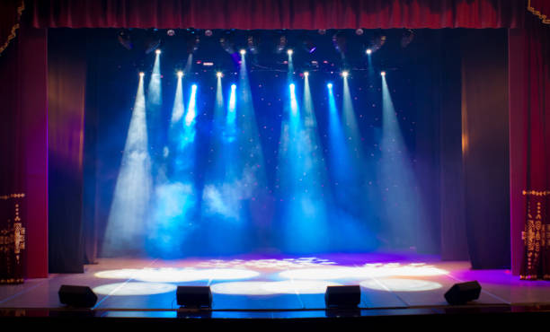 The stage of the theater illuminated by spotlights and smoke from the auditorium The stage of the theater illuminated by spotlights and smoke from the auditorium staging light stock pictures, royalty-free photos & images