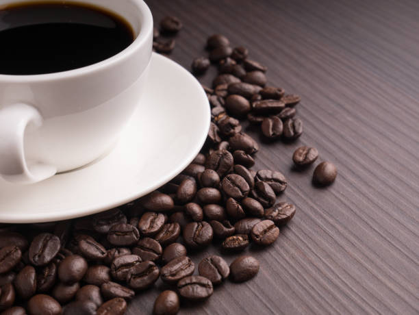 istock Black coffee cup on brown wood table with coffee bean 851174282