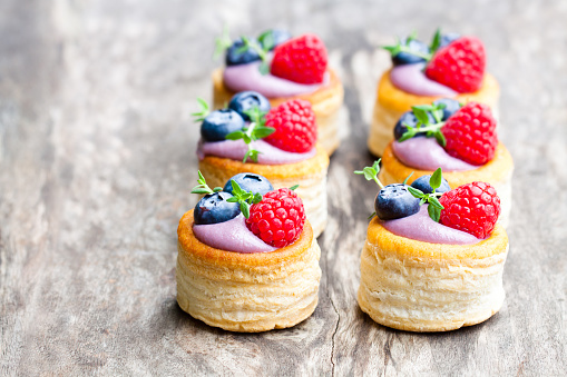puff  pastry stuffed with soft blueberry curd with berries and thyme on rustic wooden background