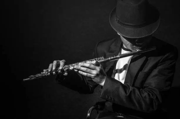 Photo of Flute music playing flutist musician performer on black background, musical instrument