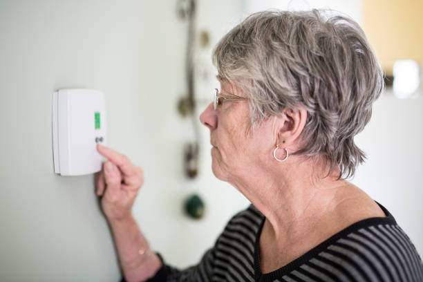istock Senior woman adjusting her thermostat 851344034