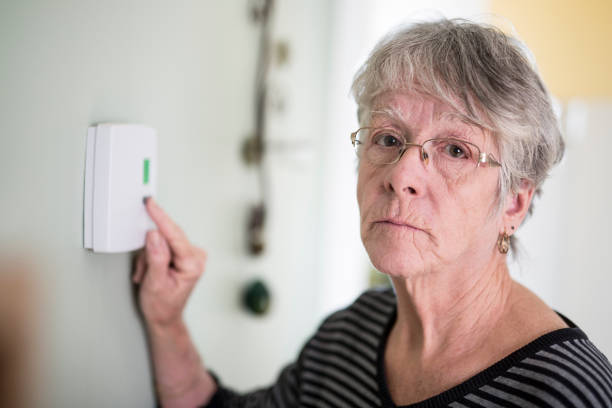 istock Senior woman adjusting her thermostat 851344104