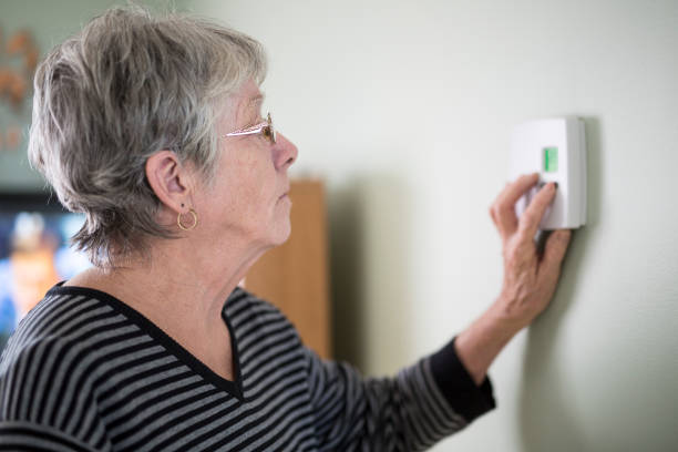istock Senior woman adjusting her thermostat 851344138