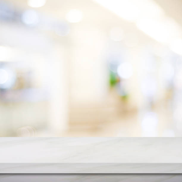 istock Empty white marble over blur store background, product and food display montage 851356358