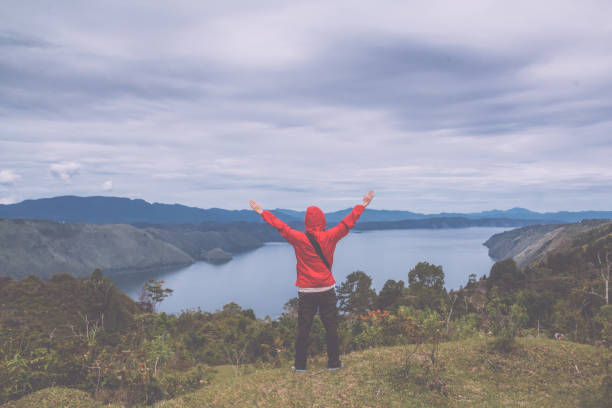 istock man standing on hill looking at the lake toba 851380022