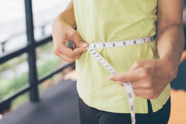 Teenage girls use their own waist measurement straps. To control the size and shape of yourself after exercise. stock photo