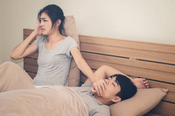A woman has a nuisance to the man he loves sleeping loud snoring.Concept of life together stock photo