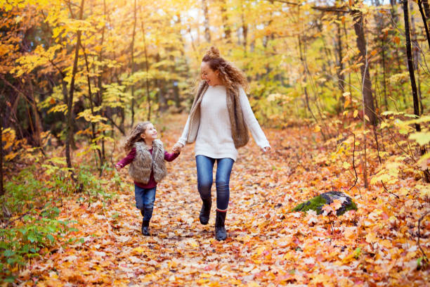 istock Young mother playing with her daughter in autumn park 851422698