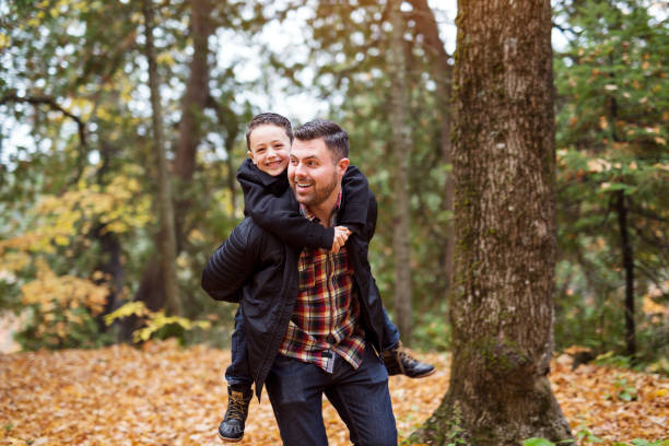 istock father and son having fun in autumn park 851423408