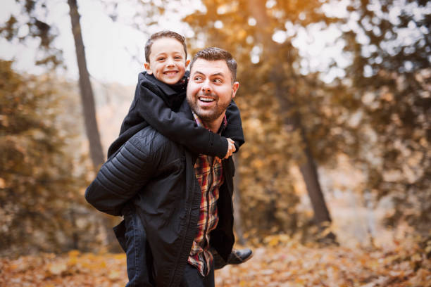 istock father and son having fun in autumn park 851423446
