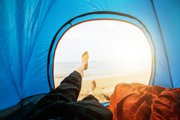 istock Couple sitting in tent by sea 851448206