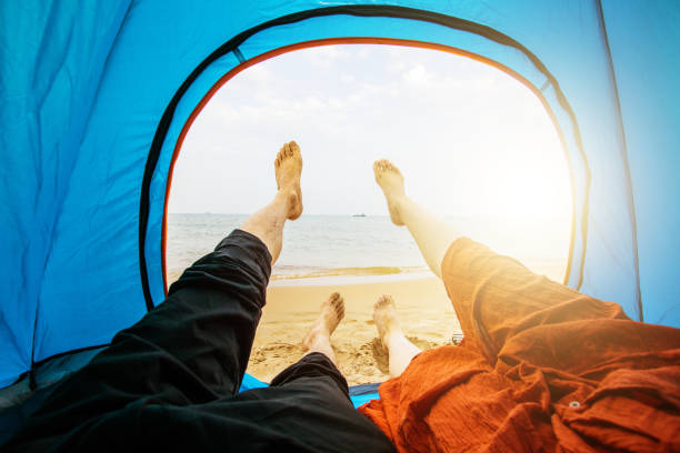 istock Couple sitting in tent by sea 851448350