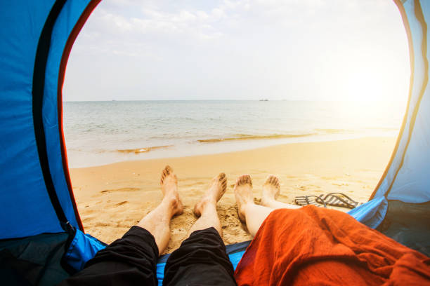 istock Couple sitting in tent by sea 851448390