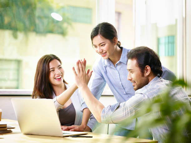 happy asian business team working together in office