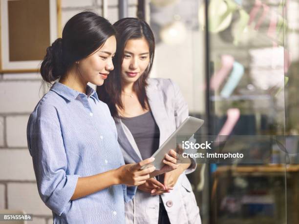 Two Asian Business Women Working Together In Office Stock Photo - Download Image Now
