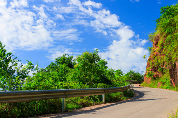 Mountain road in day with a blue sky with clouds.