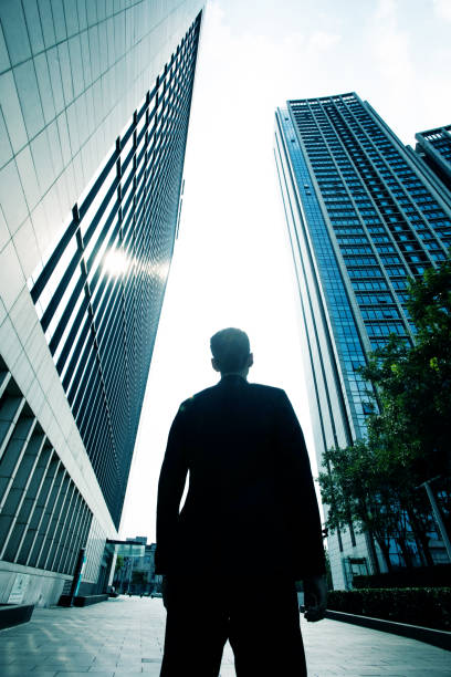 istock Businessman standing between city buildings 851475814