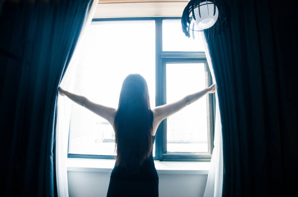 istock Woman opening curtains in the morning 851478838