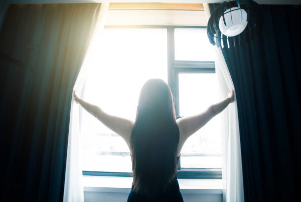 istock Woman opening curtains in the morning 851478844