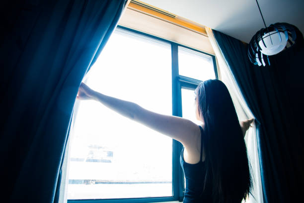 istock young woman open the curtains 851478960
